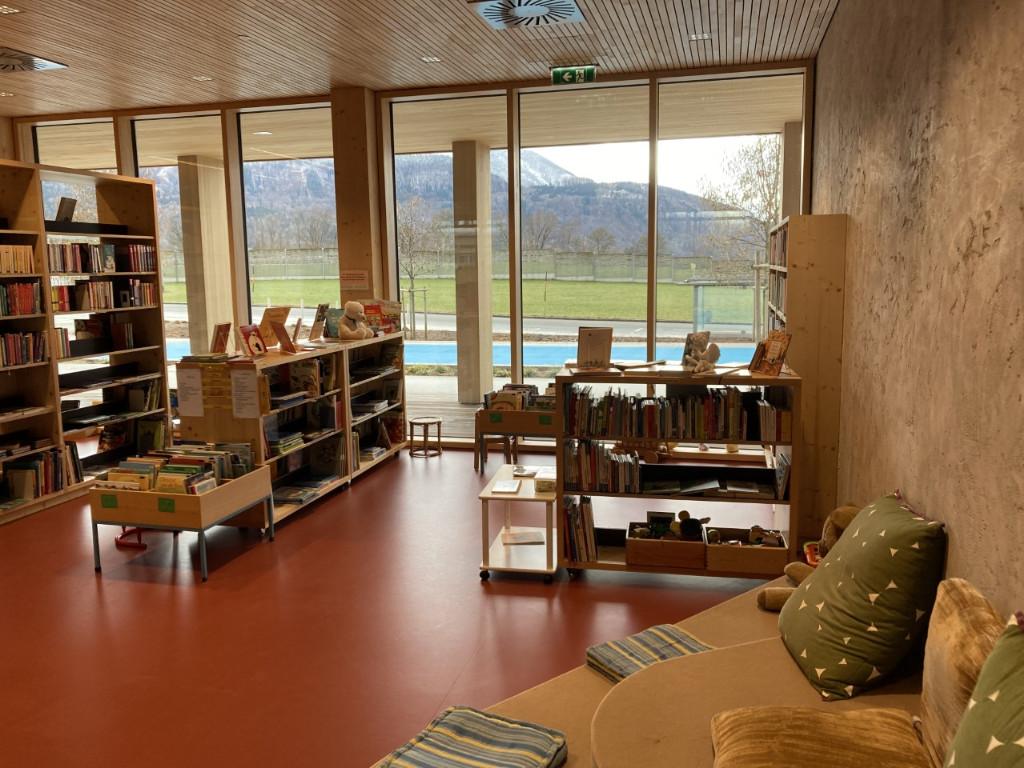 Kinderbereich mit Büchertrog, niedrigen Regalen, vorne rechts ein Couch